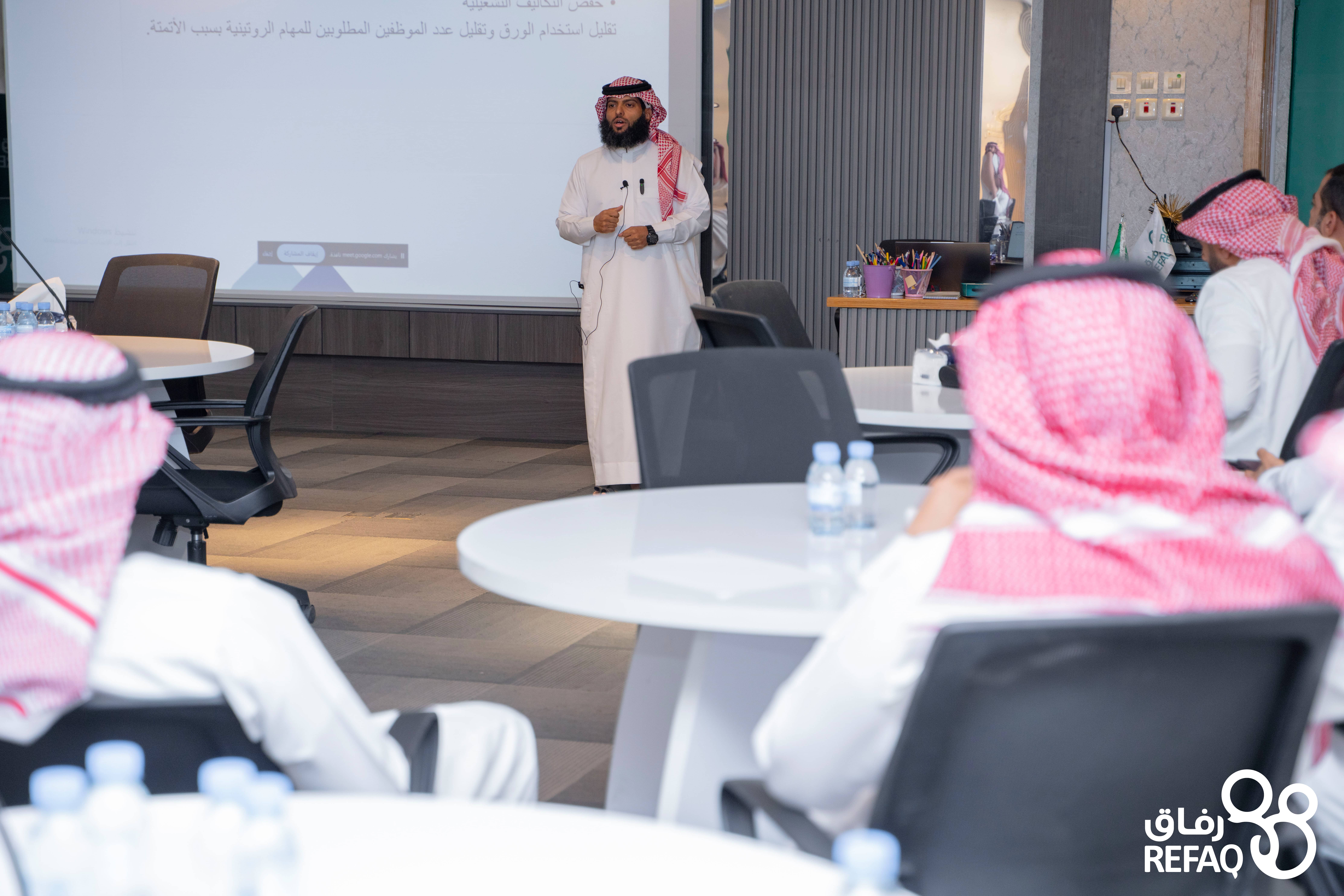 صور للمهندس عبدالكريم واقفا ًأمام جهاز العرض وامامه مجموعة من منسوبي الجمعية